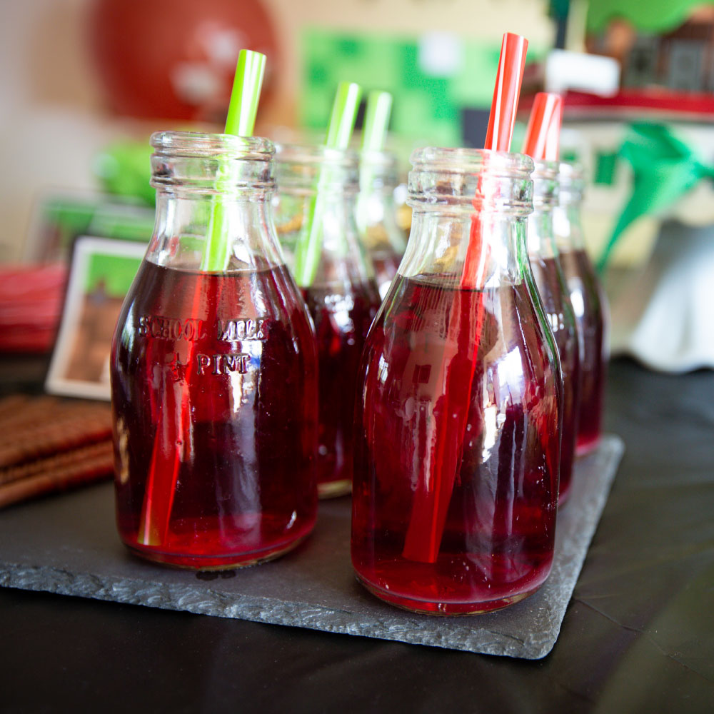 Red drinks in glass bottles and a straw